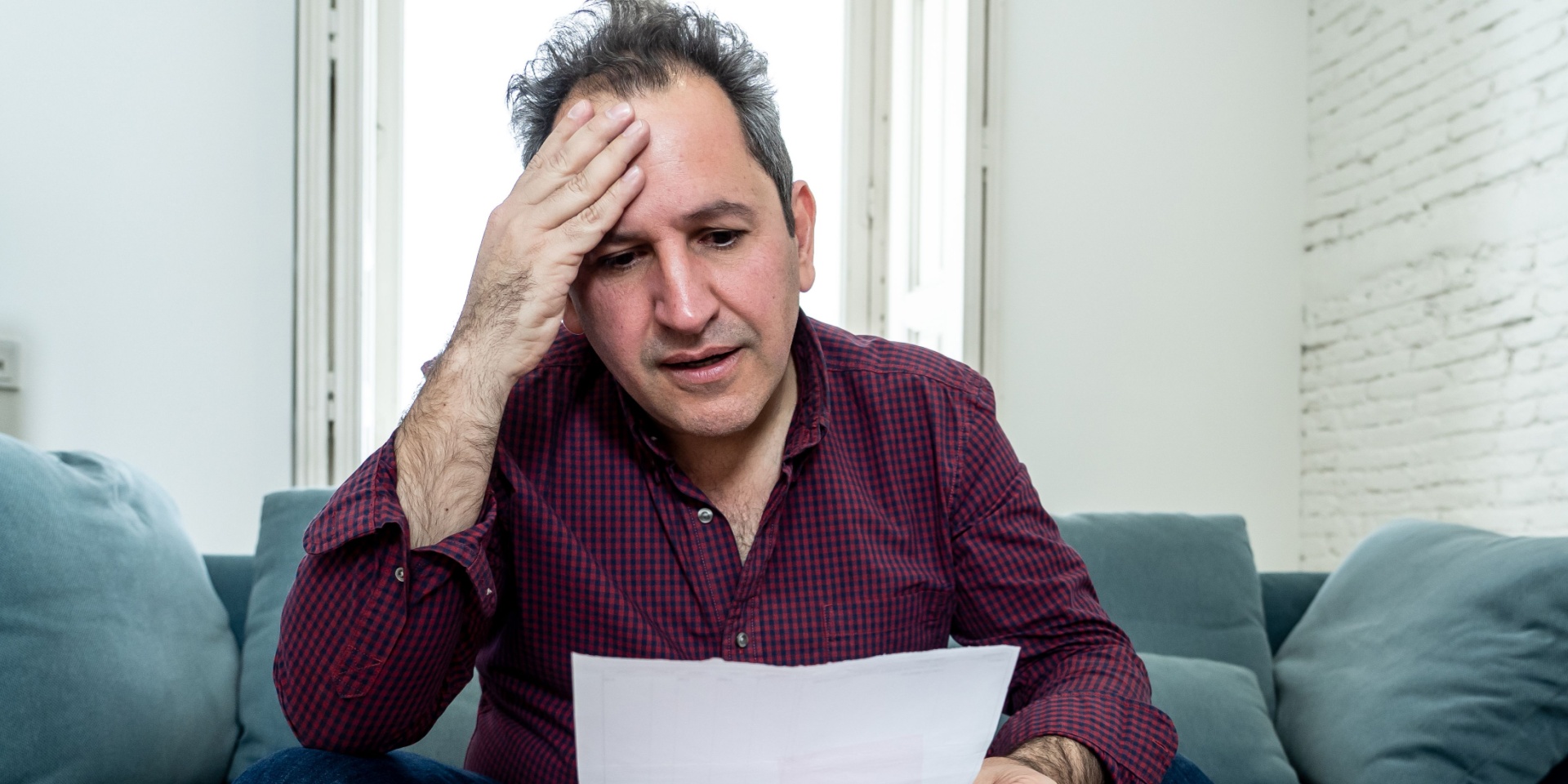 Stressed middle-aged man looking at financial paperwork