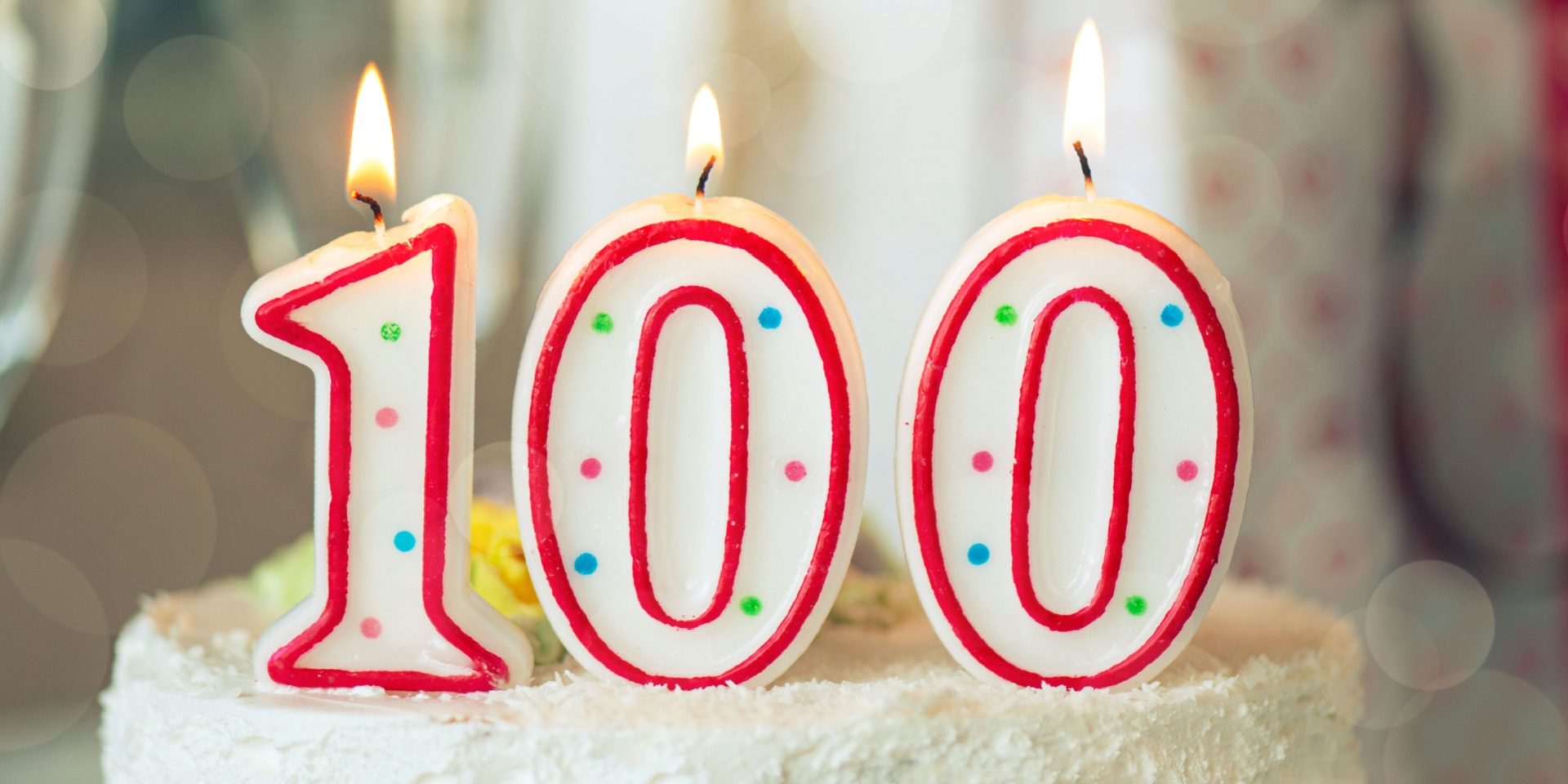 A birthday cake with a “100” candle on it