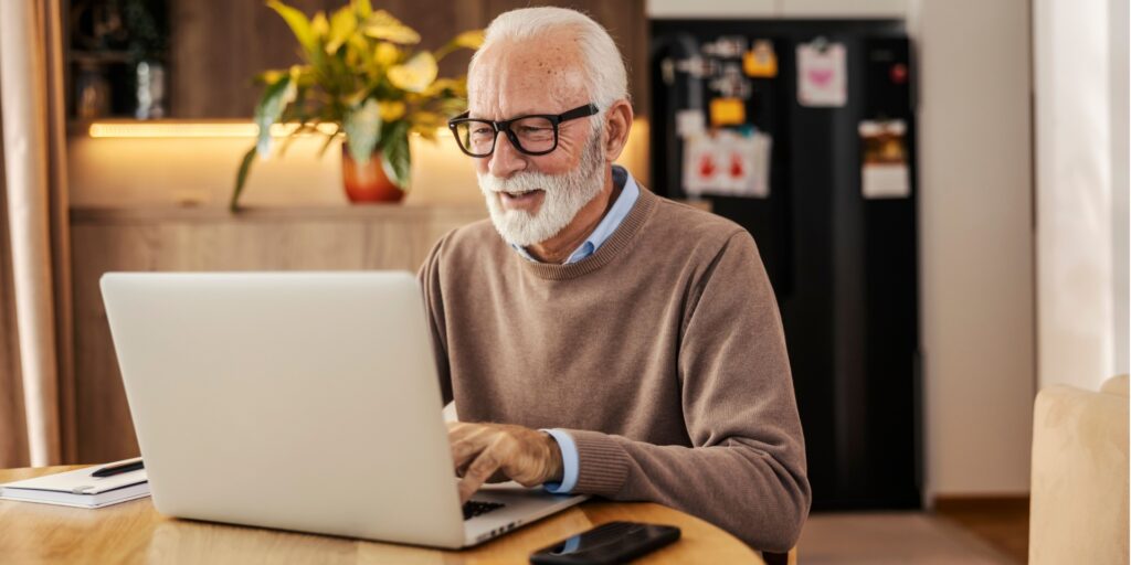 Senior man smiling as he works at home
